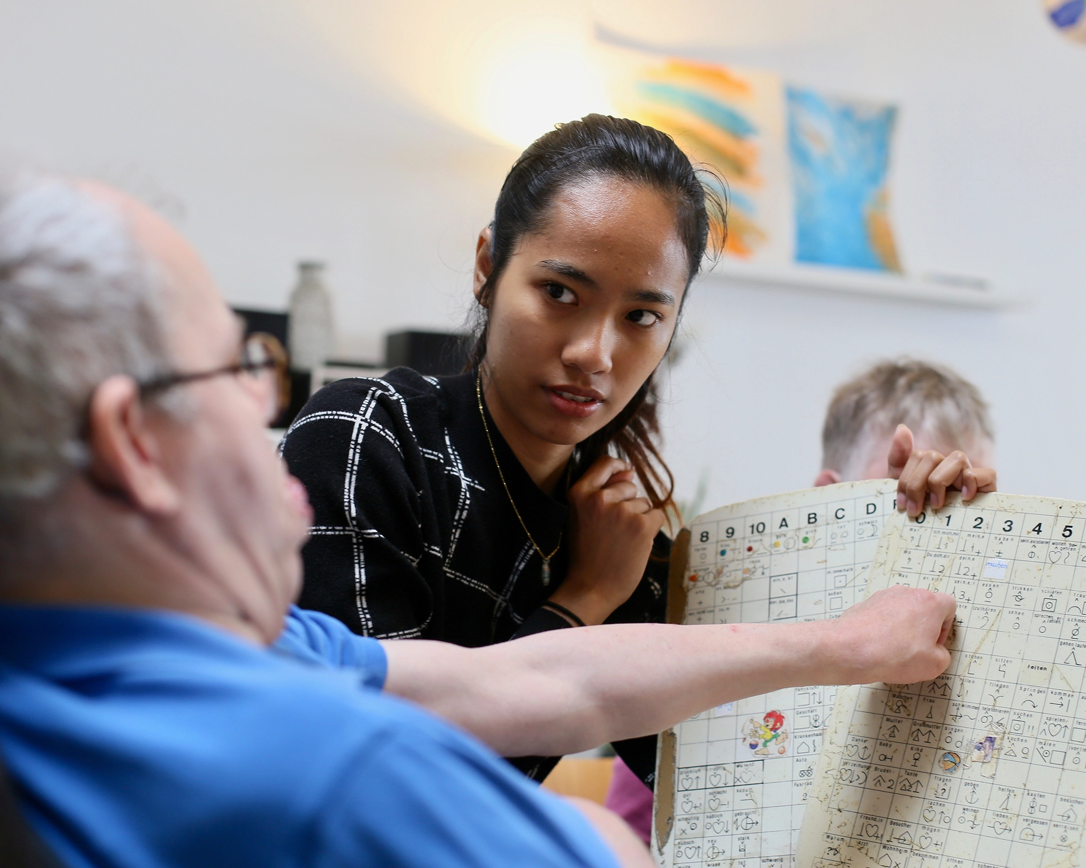Eine Person zeigt auf eine große Tafel mit Symbolen.
