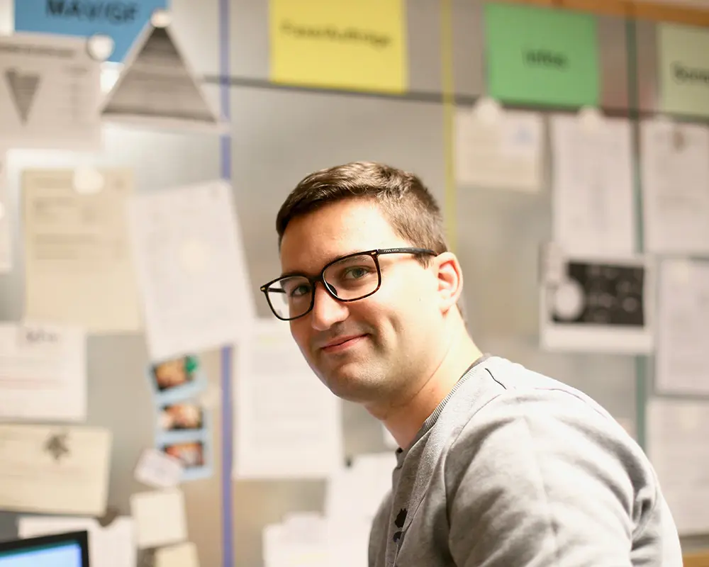 Ein Betreuer sitztc im Dienstzimmer der Wohngemeinschaften.