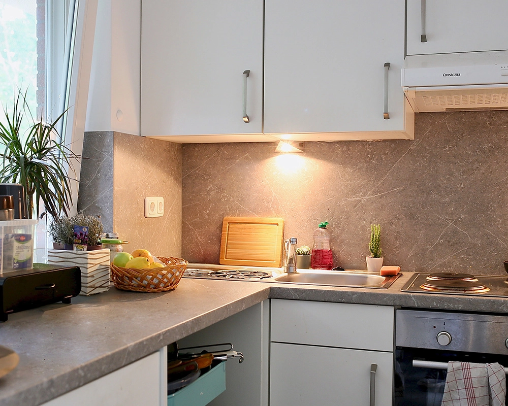 Blick in eine weße Küche des ambulant unterstützes wohnen mit Herd und Oberschränken